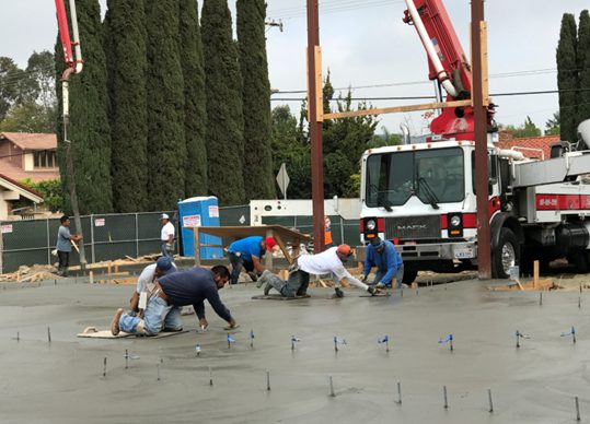Engineered concrete slab foundation pour and finishing crew by Newport Construction Group