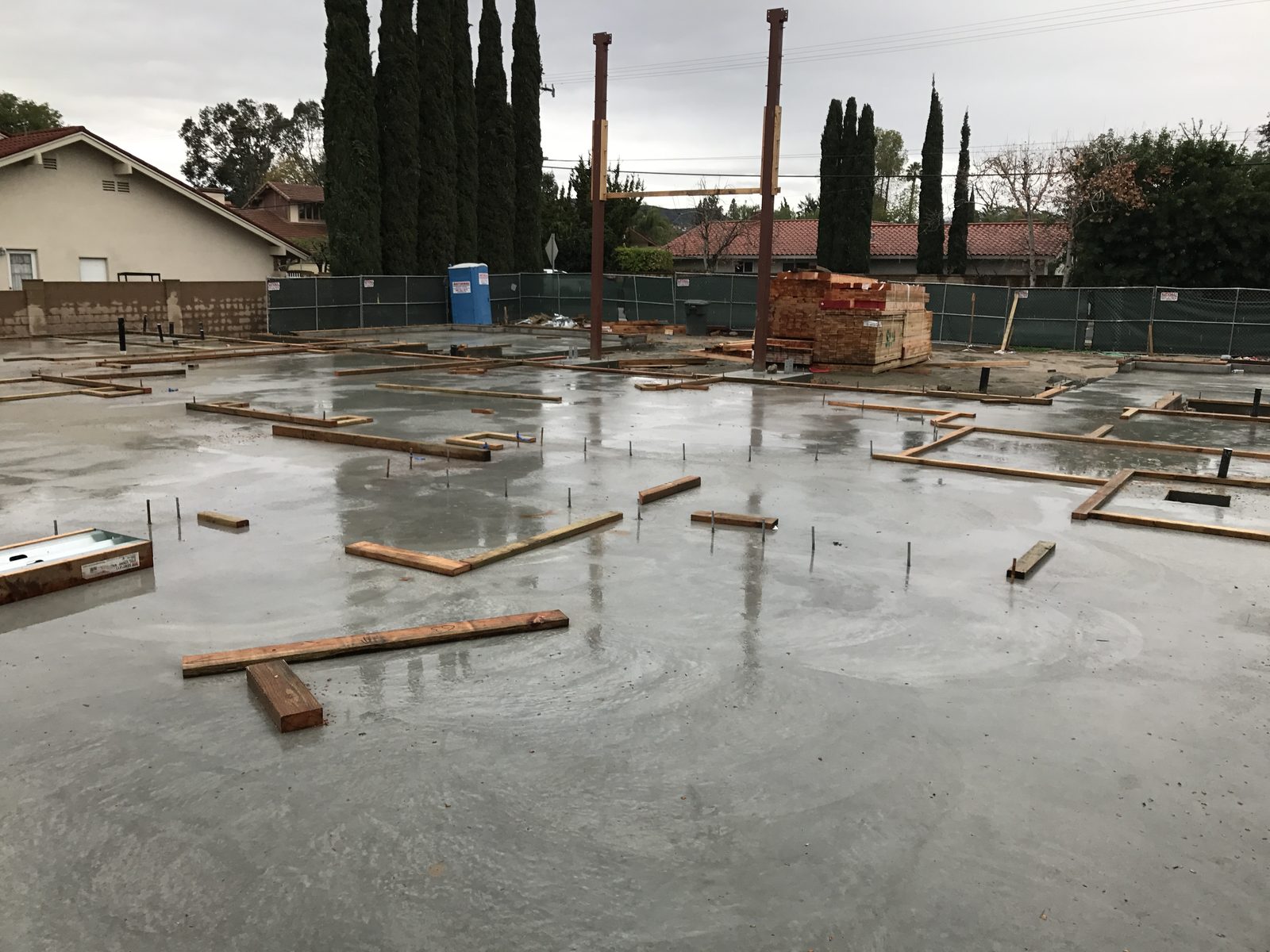 Cured concrete foundation slab and steel structural supports by Newport Construction Group in Villa Park, CA