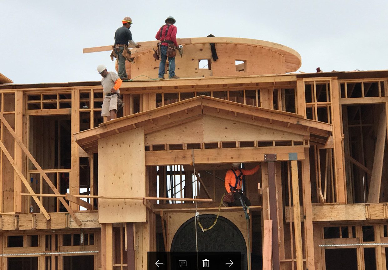 Carpenters completing roof and rotunda structural framing on a custom home by Newport Construction Group
