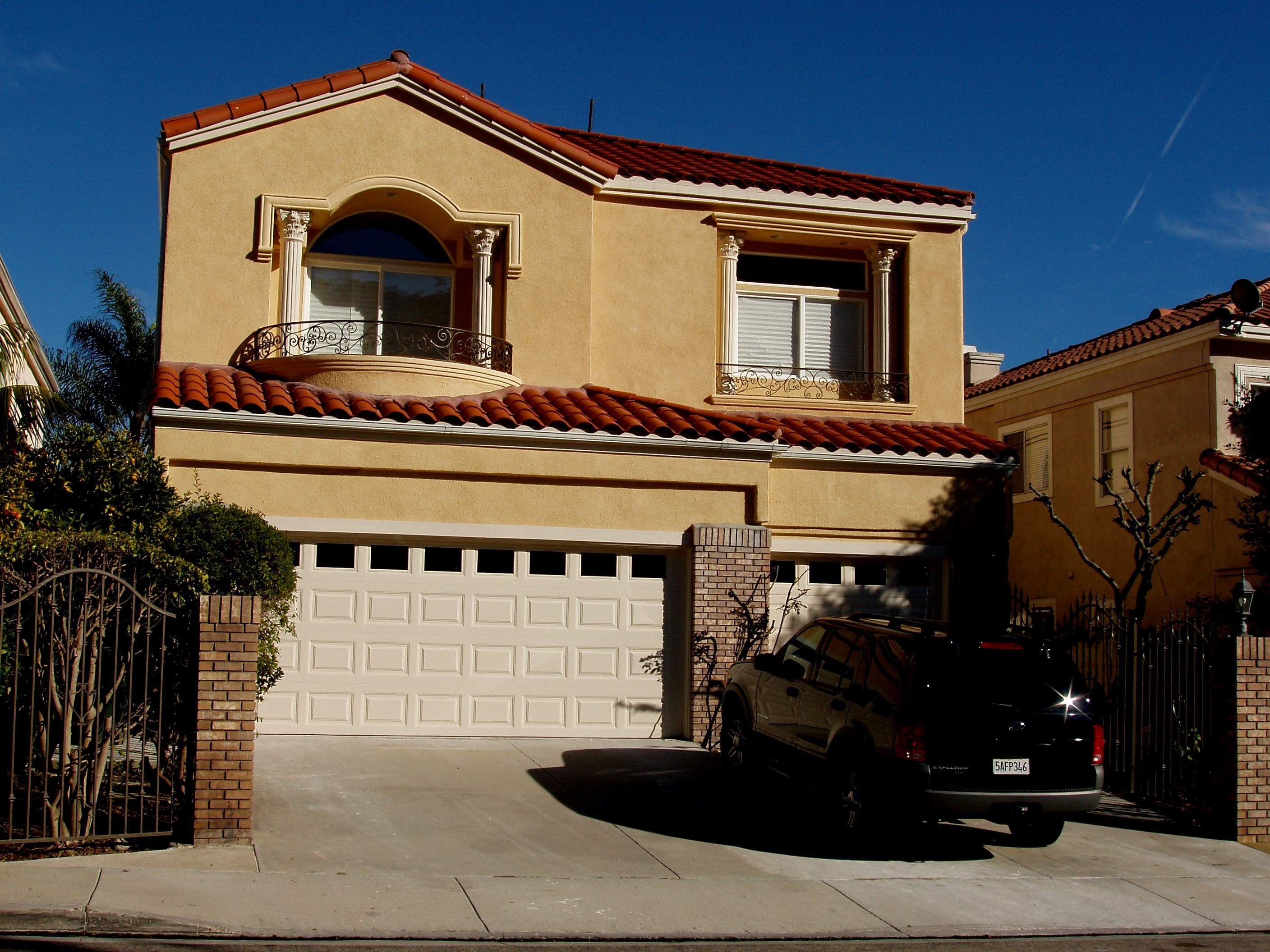 Completed two-story residential home with tile roof and three-car garage